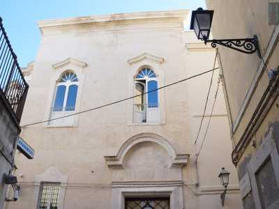 La facciata del palazzo, intonacata di bianco e conclusa da un cornicione a spiovente, � caratterizzata da una parte superiore con due finestroni allungati e sormontati da piccoli archivolti